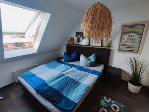 - une chambre avec un lit doté de draps bleus et une fenêtre dans l'établissement FeWo - SEEluft am Zwenkauer See, à Zwenkau