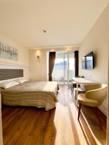 バトゥミにあるApartment in Alliance palace on the Justice sideのベッドと机とテーブルのある寝室