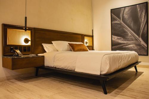 a bedroom with a large bed and a telephone at Casa Continental Hotel Boutique & Suites - Adults Only in Mérida