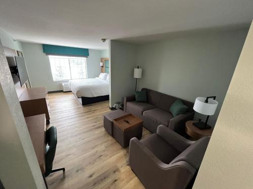 a living room with a couch and a bed at Wingate By Wyndham Mansfield Ontario in Mansfield