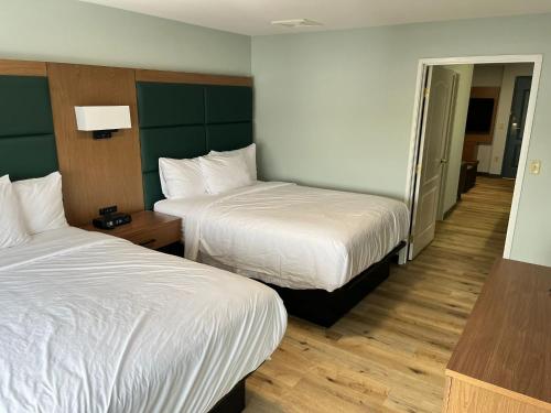a hotel room with two beds and a hallway at Wingate By Wyndham Mansfield Ontario in Mansfield