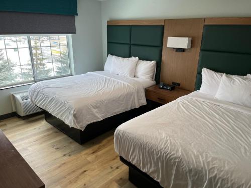 a hotel room with two beds and two windows at Wingate By Wyndham Mansfield Ontario in Mansfield
