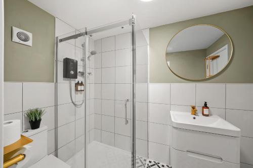 a bathroom with a shower and a sink and a mirror at BridgeCity Spectacular Morden 2 bedroom flat in Ashford Town Centre in Kent