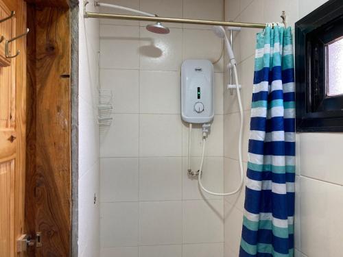 y baño con ducha y cortina de ducha azul y blanco. en Palm Villas Estate, en Bijilo