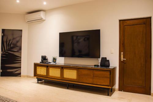 a living room with a large television on the wall at Casa Continental Hotel Boutique & Suites - Adults Only in Mérida