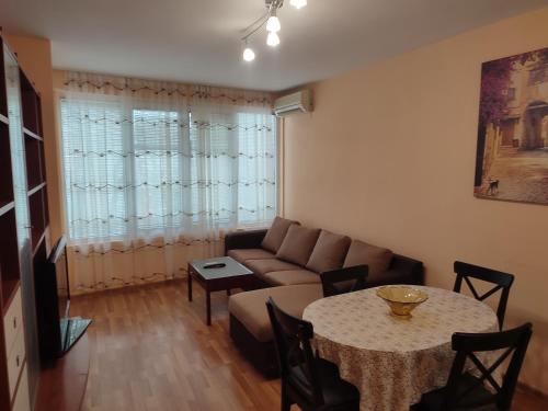 een woonkamer met een bank en een tafel bij Primorski Apartment in Varna