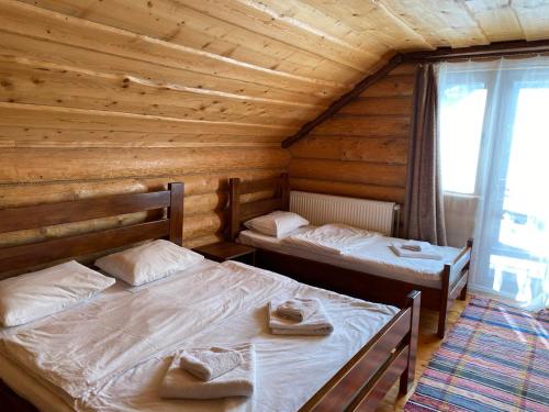 1 Schlafzimmer mit 2 Betten in einer Holzhütte in der Unterkunft Шепіт річки in Synewyr