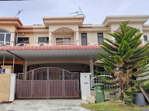 イポーにあるIpoh Station 18 Homestayの門とヤシの木のある家