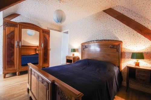 - une chambre avec un grand lit en bois et une commode dans l'établissement 604 - Maison avec grand jardin calme et paisible proximité centre et plage d'Erquy, à Erquy