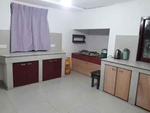 a kitchen with brown cabinets and a purple curtain at G7 Villa in Weligama