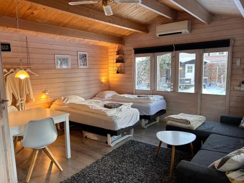 um quarto com duas camas, uma mesa e um sofá em Piccobello Bed & Breakfast Valløby Køge em Valløby