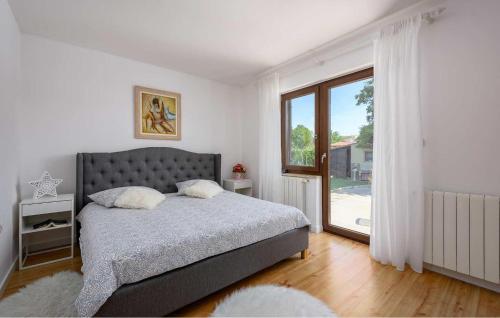 um quarto com uma cama e uma grande janela em Haus Nono em Sveti Petar u Šumi