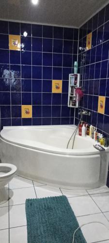 a bathroom with a tub and a blue tiled wall at Kvitkovyi Rai З червня басейн з підігрівом 10 на 5 метрів in Slavske