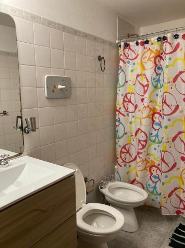 a bathroom with a toilet and a shower curtain at Casa Nelly in Playa Unión