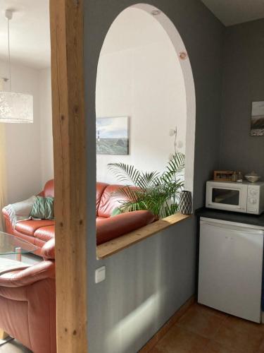 an archway in a kitchen with a couch and a microwave at Fewo - Am Mühlenteich in Wismar