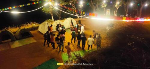a group of people standing on a stage at night at Bhandardara Campthrill Adventure in Bhandardara