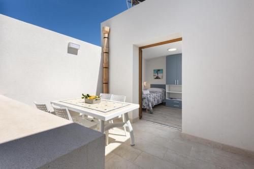 Una habitación con una mesa y sillas y un dormitorio. en Bedda Luna Apartments, en San Vito lo Capo