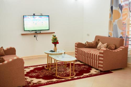 uma sala de estar com dois sofás e uma televisão em Mama's Home Stay em Dodoma