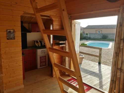 eine Leiter in einer Hütte mit einer Küche und einem Pool in der Unterkunft Le chalet de Fréd et Line in La Garnache