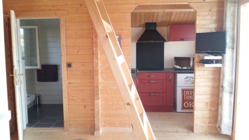 eine Treppe, die zu einer Küche mit roten Schränken führt in der Unterkunft Le chalet de Fréd et Line in La Garnache