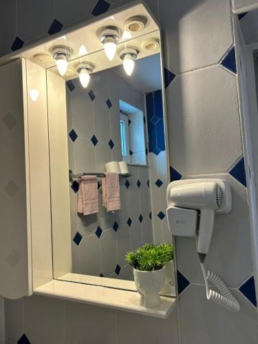 a bathroom with a mirror and a hair dryer at Ambra Room's in Braşov