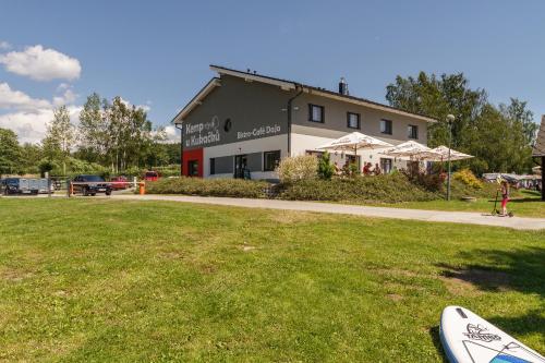 a building with a surfboard sitting in the grass at Camping u Kukačků in Horní Planá