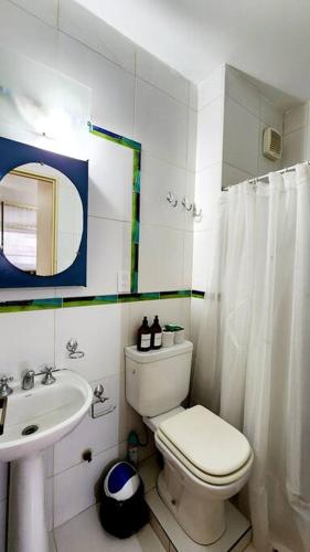 a white bathroom with a toilet and a sink at Céntrico departamento porteño in Buenos Aires