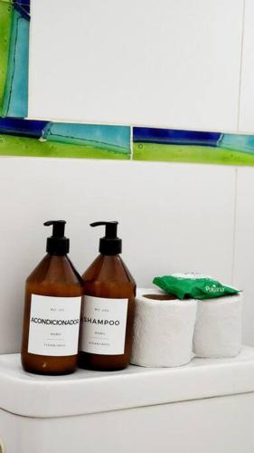 two bottles of soap and toilet paper on a shelf at Céntrico departamento porteño in Buenos Aires