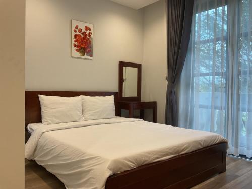 a bedroom with a large bed with a window at Green Inn Phu Quoc Hotel in Phu Quoc