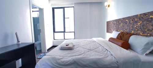 a bedroom with a large white bed with a window at Top Tier Home in Nairobi