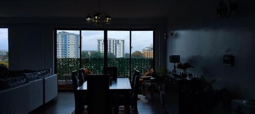 a living room with a table and a large window at Top Tier Home in Nairobi