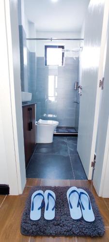 a bathroom with a pair of flip flops on a rug at Top Tier Home in Nairobi