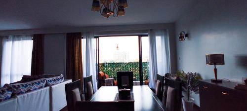 a dining room with a table and chairs and a window at Top Tier Home in Nairobi