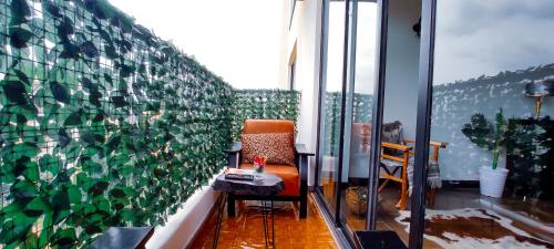 a chair and a table in a room with a wall of windows at Top Tier Home in Nairobi