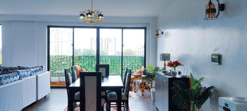 a dining room with a table and a large window at Top Tier Home in Nairobi