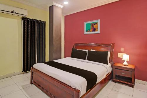 una camera da letto con un letto con una parete rossa di Hotel O Ruma Near Nampally Railway Station a Hyderabad