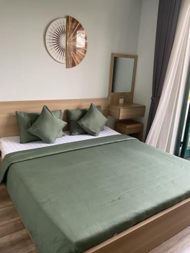 a bedroom with a large bed with a mirror on the wall at Green Inn Phu Quoc Hotel in Phu Quoc