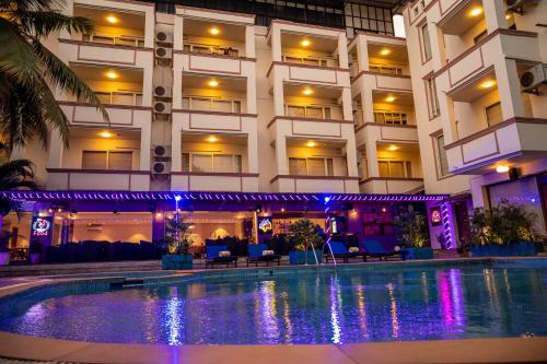 a hotel with a swimming pool in front of a building at La Oasis by Meraden ,Goa in Anjuna