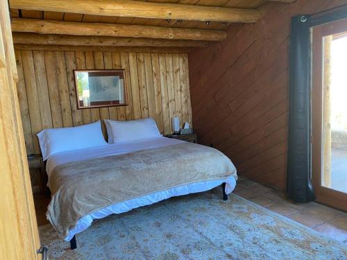 a bedroom with a bed in a wooden wall at Taos Mountain Views- Cozy Home-Special Rates in El Prado