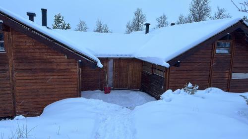 garaż pokryty śniegiem i śniegiem na dachu w obiekcie Kinnkosen - cabin with panoramic view for 6 persons w mieście Holo