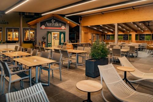 an empty restaurant with wooden tables and chairs at Fischgasthof Aumüller in Obermühl