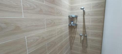 a shower stall in a bathroom with wooden tiles at Dar Assalam in Oualidia