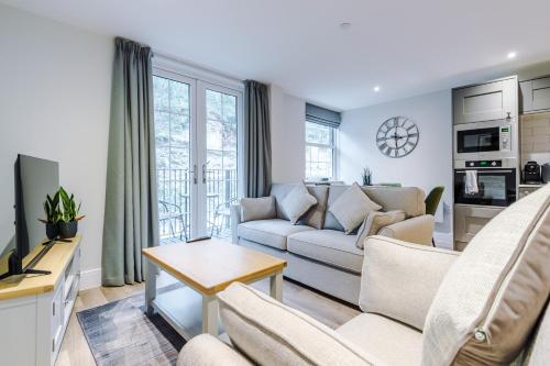 a living room with a couch and a table at Rock Mill - Deluxe Holiday Apartments in Stoney Middleton