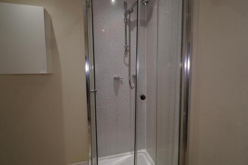 a shower with a glass door in a bathroom at Spacious 2 bed apt next to Royal Mile & Waverley in Edinburgh