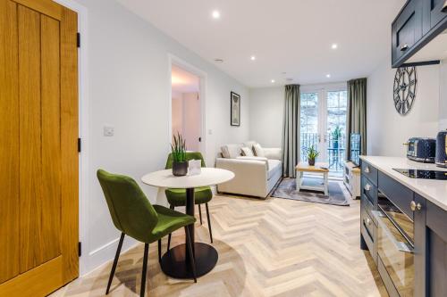 a kitchen with a table and a living room at Rock Mill - Deluxe Holiday Apartments in Stony Middleton