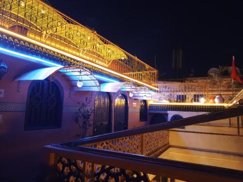 a lit up building with an umbrella at night at RIAD ESMERALDA By Dar Ouezzani in Rabat