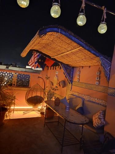 a patio with a table and chairs and lights at RIAD ESMERALDA By Dar Ouezzani in Rabat