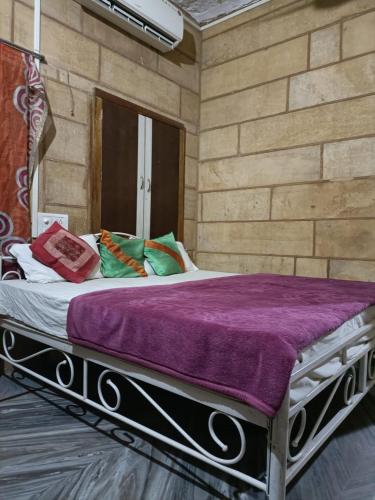 1 dormitorio con 1 cama grande con sábanas moradas en Hotel peris en Jaisalmer