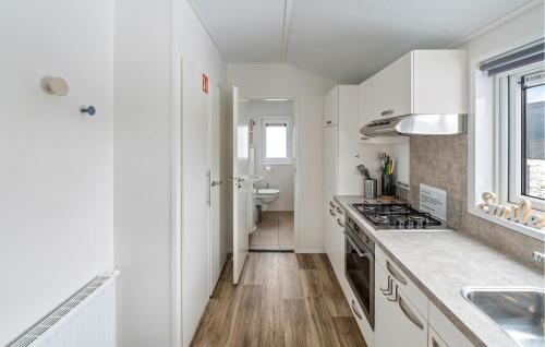 a kitchen with white cabinets and a stove top oven at 2 Bedroom Beautiful Home In Ssel in Süsel