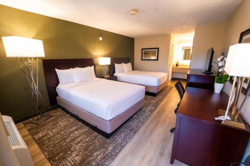 Pokój hotelowy z 2 łóżkami i biurkiem w obiekcie Mai Hana Hotel w Orlando